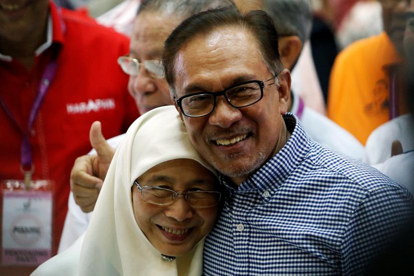 Malaysia`s politician Anwar Ibrahim celebrates with his wife Wan Azizah after winning the by-election in Port Dickson, Malaysia Oct 13. REUTERS