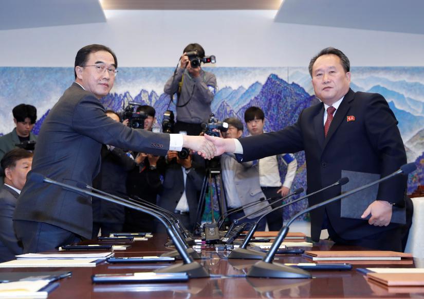 North Korea's Ri Son Gwon shakes hands with South Korean Unification Minister Cho after exchanging the joint statement during their meeting at the truce village of Panmunjom, Oct 15. Yonhap via REUTERS