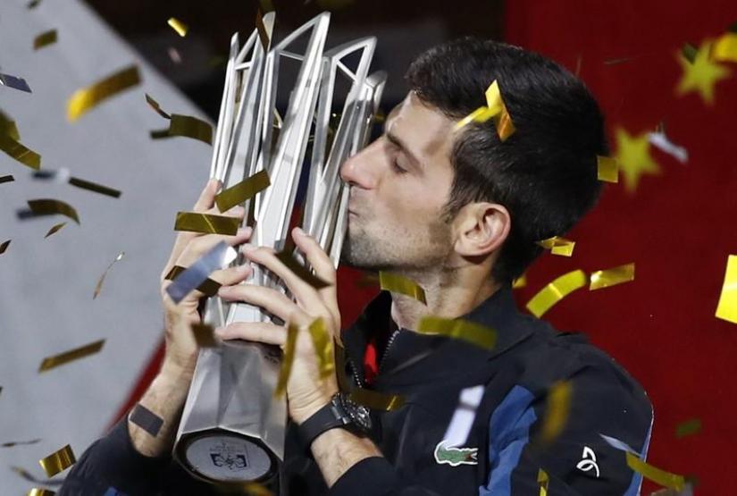 Djokovic of Serbia celebrates with the trophy after winning the final of Shanghai Masters against Borna Coric of Croatia. REUTERS