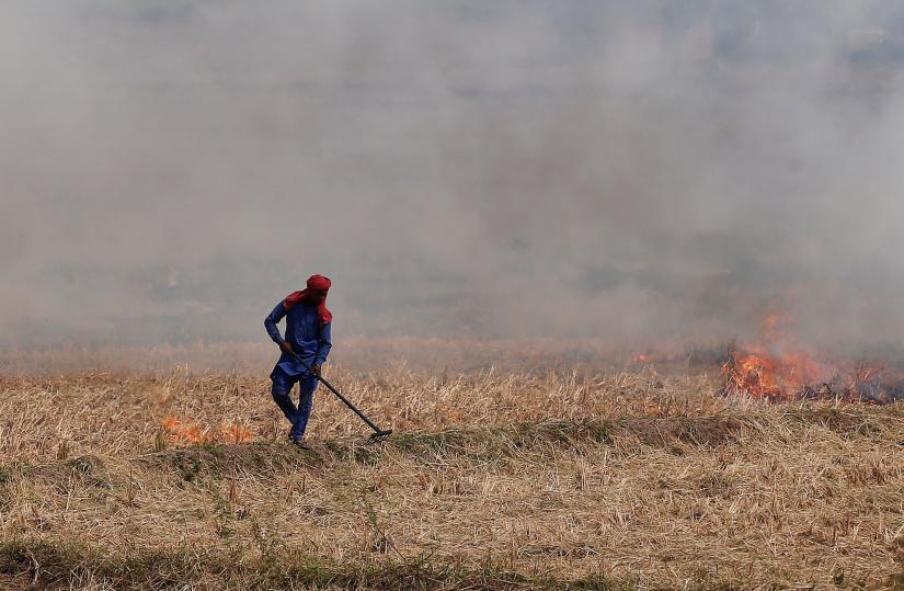 A farmer burns the stubble in a rice field in Zirakpur in the northern state of Punjab, India, October 10, 2018.  Picture taken October 10, 2018. REUTERS/Adnan Abidi