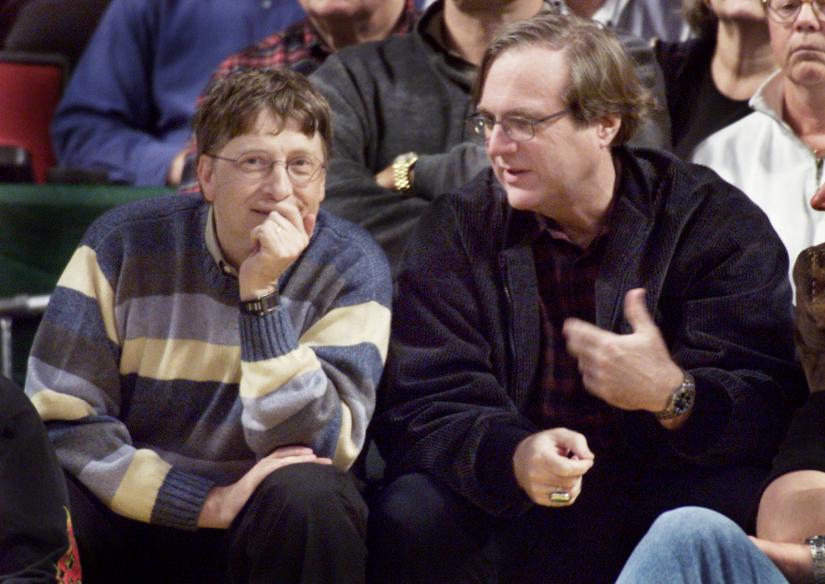 Microsoft co-founders Bill Gates (L) and Paul Allen (R) chat at courtside during aNBA game between the Seattle SuperSonics and the Portland Trailblazers in Seattle in 2003. REUTERS/file photo