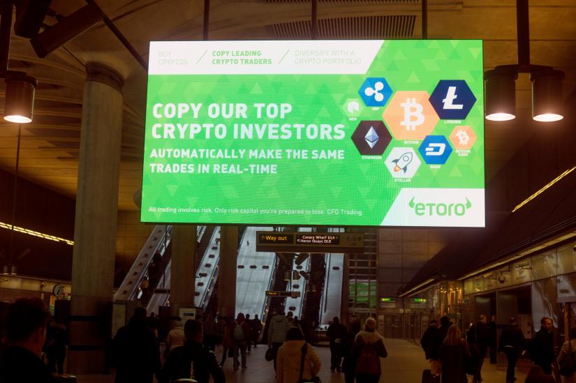 Giant electronic billboards display adverts for crypto currency investment companies at Canary Wharf tube station in London, Britain Apr 6, 2018. REUTERS/file photo