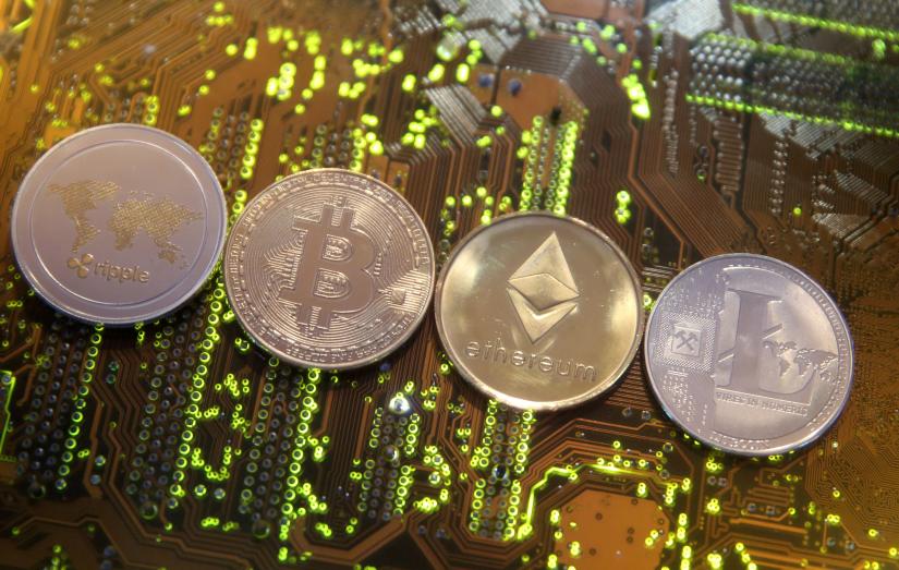 Representations of the Ripple, Bitcoin, Etherum and Litecoin virtual currencies are seen on a PC motherboard in this illustration picture, Feb 13, 2018. REUTERS/file photo