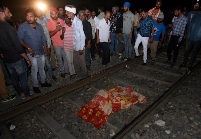 People surround the body of a victim lying on a railway track after an accident in Amritsar, India, October 19, 2018. REUTERS