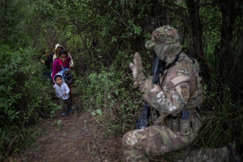 A member of the U.S. Border Patrol Tactical Unit (BORTAC) acknowledges family members after they illegally crossed the Rio Grande river into the United States from Mexico in Fronton, Texas, October 18, 2018. REUTERS