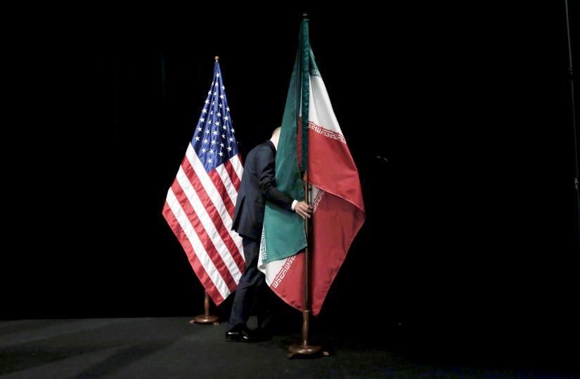 A staff member removes the Iranian flag from the stage during the Iran nuclear talks at the Vienna International Center in Vienna, Austria July 14, 2015. REUTERS/FILE PHOTO