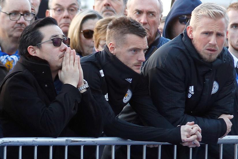 Son of Leicester City`s owner Thai businessman Vichai Srivaddhanaprabha, and players look at tributes left for Vichai and four other people who died in helicopter crash. REUTERS