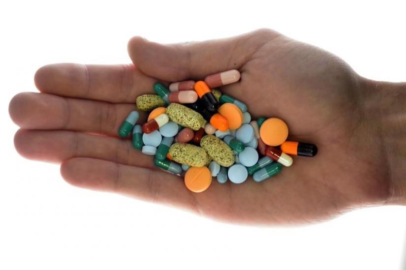 A person holds pharmaceutical tablets and capsules in this picture illustration taken in Ljubljana September 18, 2013.  REUTERS FILE PHOTO