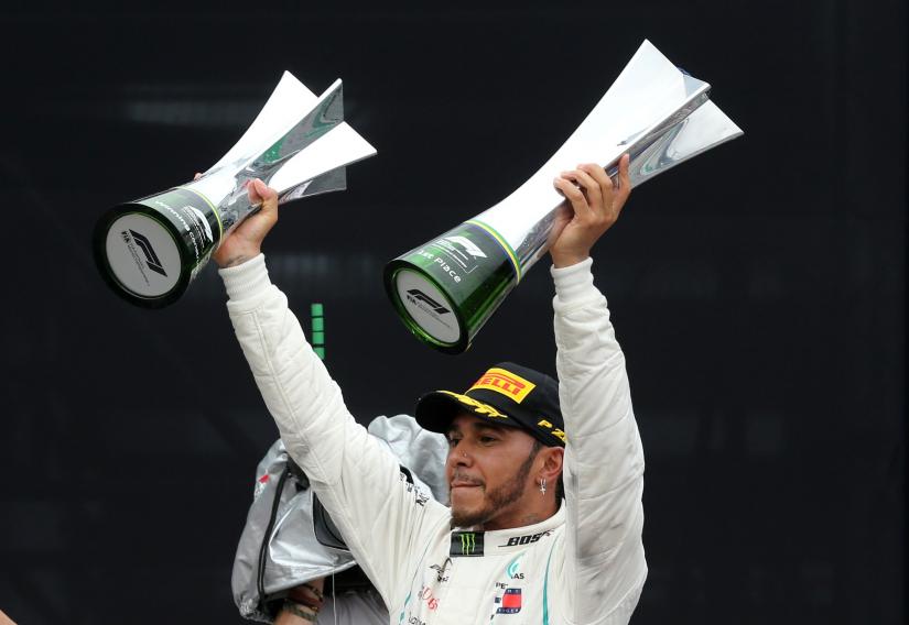 Brazilian Grand Prix - Sao Paulo, Brazil - Nov 11, 2018 Mercedes` Lewis Hamilton celebrates after winning the race with the constructors championship trophy and the race trophy. REUTERS