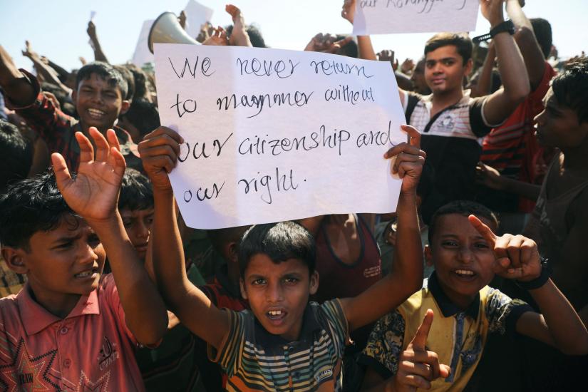 A boy holds a placard as hundreds of Rohingya refugees protest against their repatriation at the Unchiprang camp in Teknaf, Bangladesh November 15, 2018. REUTERS