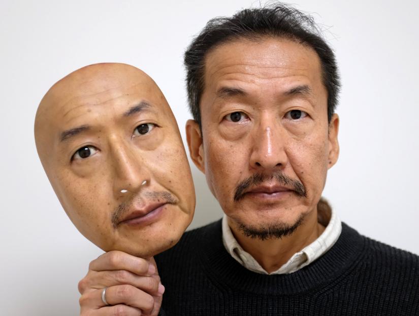 REAL-f Co. President Osamu Kitagawa shows off a super-realistic face mask at his factory in Otsu, western Japan, November 15, 2018. REUTERS