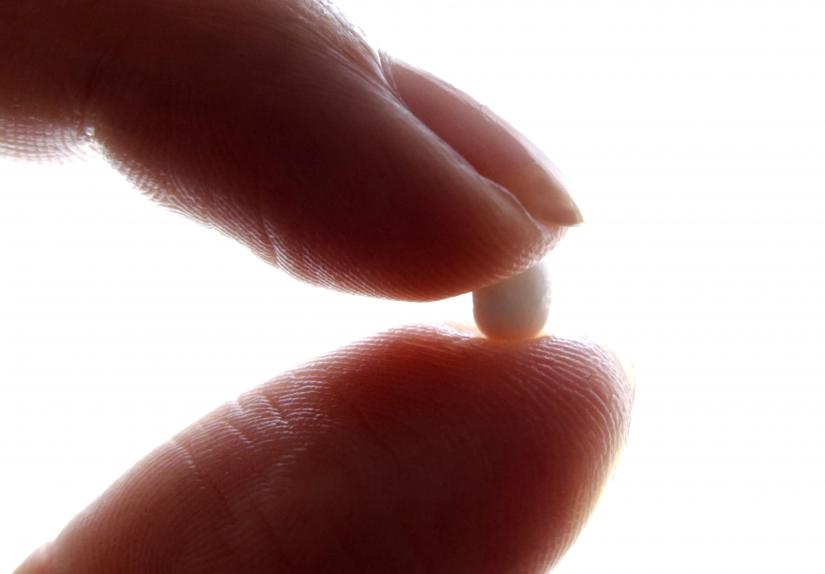 An illustration picture shows a woman holding a birth control pill. Reuters