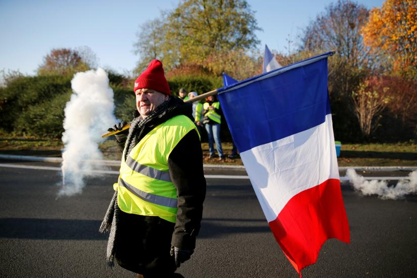 Francis Bouffletz, a retired 64-year-old, wears a yellow vest, a symbol of French drivers` nationwide protest against higher fuel prices, on a road block near the entrance of the Paris-Brussels motorway in Cambrai, France, November 17, 2018. REUTERS