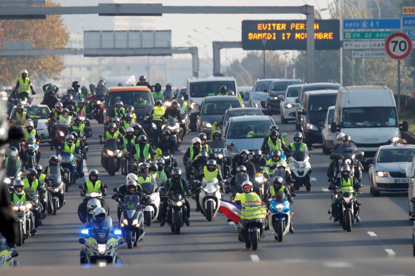 Motorcyclists wearing yellow vests, a symbol of a French drivers` protest against higher fuel prices,  move a a snail`s pace as they block the ring road in Paris, France, November 17, 2018. REUTERS