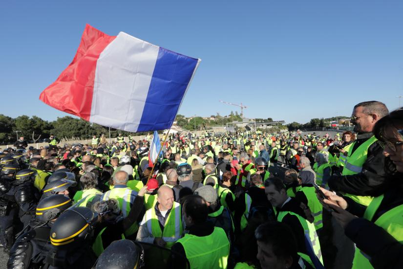 French CRS form a line as people wearing yellow vests, a symbol of a French drivers` protest against higher fuel prices, block the motorway in Antibes, France, November 17, 2018. REUTERS