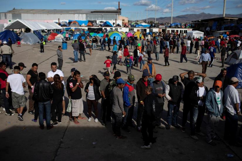 Migrants, part of a caravan of thousands from Central America trying to reach the United States, line up in a temporary shelter in Tijuana, Mexico, December 2, 2018. REUTERS/FILE PHOTO