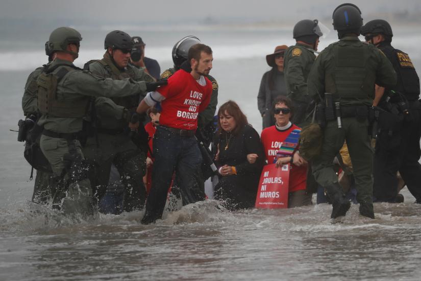 US Customs and Border Protection (CBP) officials detain a man during a gathering in support of the migrant caravan in San Diego, U.S., close to the border wall between the United States and Mexico, Dec 10, 2018. REUTERS