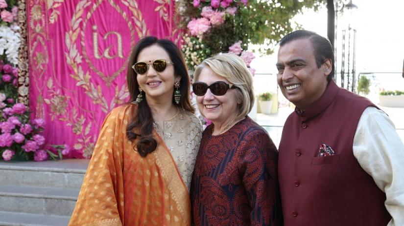 Former U.S. Secretary of State Hillary Clinton poses with Mukesh Ambani, Chairman of Reliance Industries, and his wife Nita Ambani after her arrival in Udaipur to attend pre-wedding celebrations of their daughter Isha Ambani in the desert state of Rajasthan, India, December 8, 2018. Reliance Industries/Handout via REUTERS