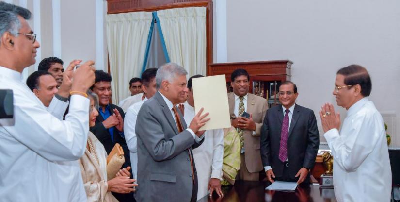 Ranil Wickremesinghe, ousted prime minister in October, takes his oath for the same post before Sri Lanka`s President Maithripala Sirisena during his swearing-in ceremony in Colombo, Sri Lanka December 16, 2018. President Media Division/Handout via REUTERS