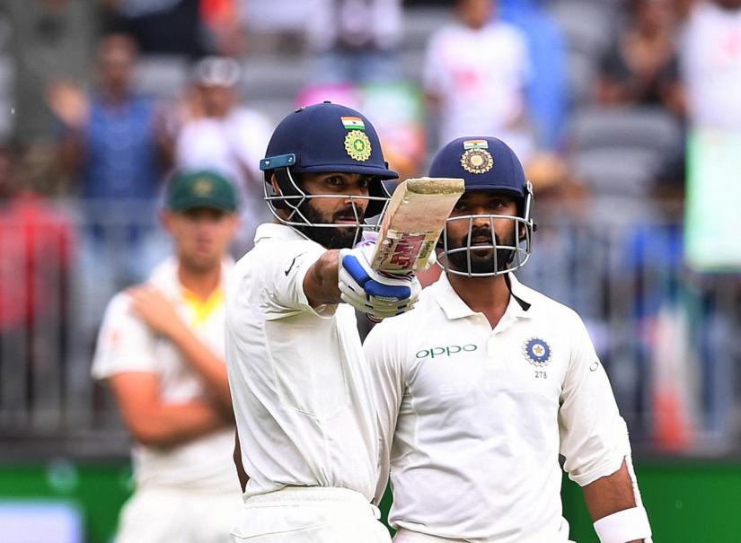India`s captain Virat Kohli raises his bat after scoring his half century on day two of the second test match between Australia and India at Perth Stadium in Perth, Australia, December 15, 2018. AAP/Dave Hunt/via REUTERS