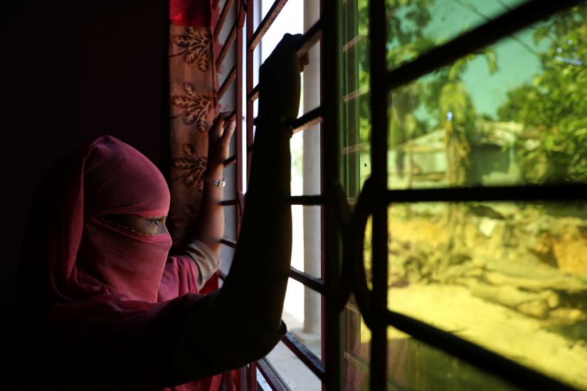 A 12 year old Rohingya girl who worked as domestic help in a house in Bangladesh, looks out the window at an undisclosed location near Cox`s Bazar, Bangladesh, November 8, 2017. REUTERS