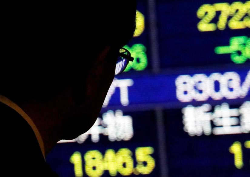 A man looks at an electronic stock quotation board outside a brokerage in Tokyo, Japan, November 13, 2018. REUTERS/FILE PHOTO