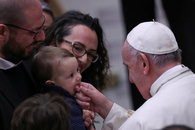 Pope Francis plays with a baby during a special audience to deliver a Christmas message to Vatican workers in Paul VI hall at the VaticanDecember 21, 2018. REUTERS