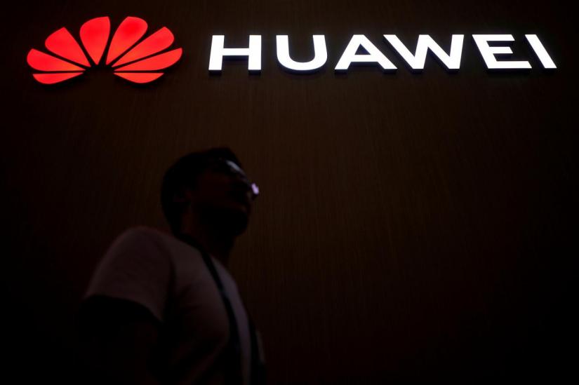 A man walks past a sign board of Huawei at CES (Consumer Electronics Show) Asia 2018 in Shanghai, China June 14, 2018. REUTERS/FILE PHOTO