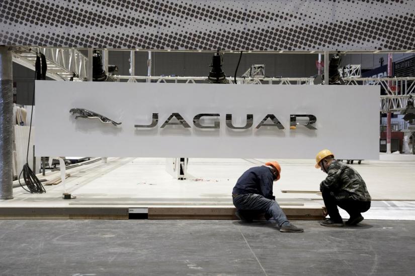 Workers set up the booth for British car manufacturer Jaguar Land Rover`s Jaguar brand inside the National Exhibition and Convention Center, the venue for the upcoming China International Import Expo (CIIE), in Shanghai, China October 28, 2018. REUTERS