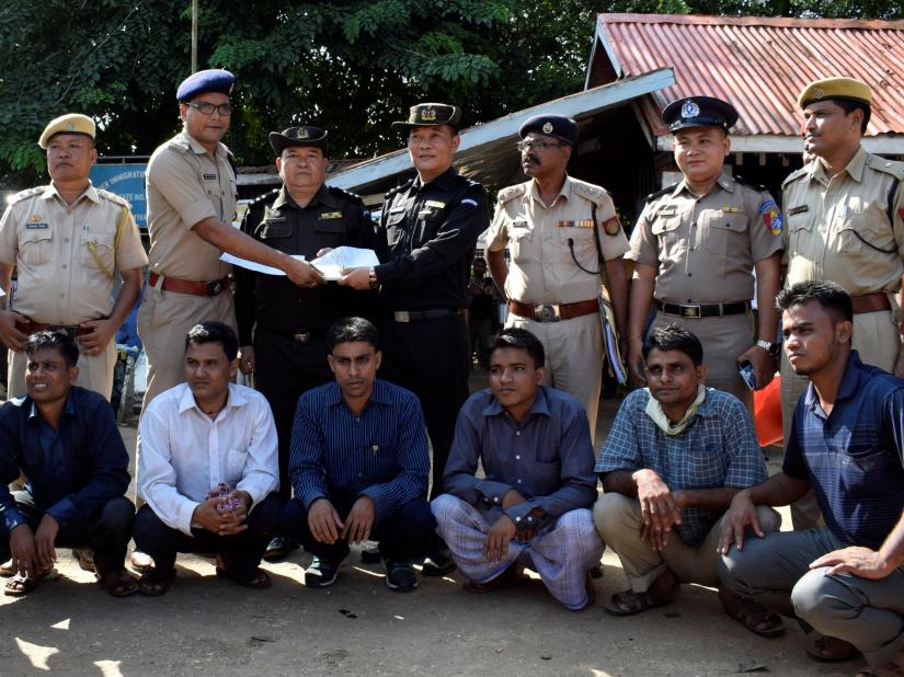 The seven Rohingya men to be deported sit as Indian and Myanmar security officials exchange documents before their deportation on India-Myanmar border at Moreh in the northeastern state of Manipur, India, October 4, 2018. REUTERS