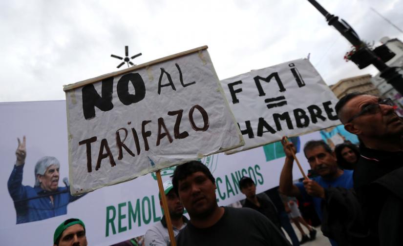 Demonstrators hold signs during a protest against a cost increase in public and utility services in Buenos Aires, Argentina, January 10, 2019. The signs reads 'No to the increase in utility service tariffs' (L) and “IMF (International Monetary Fund) = Hunger'. REUTERS