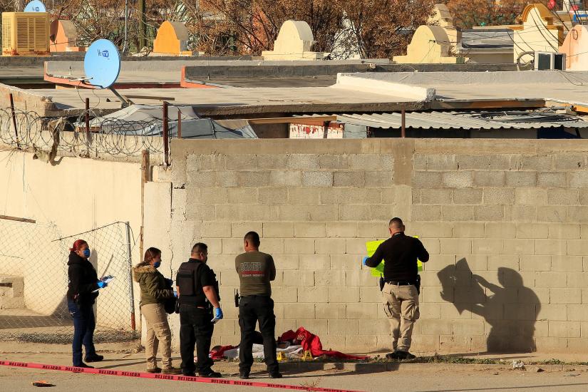 Forensic technicians work at a crime scene where a beheaded body was left wrapped in blankets with a message attached, according to local media, in Ciudad Juarez, Mexico December 21, 2018. REUTERS