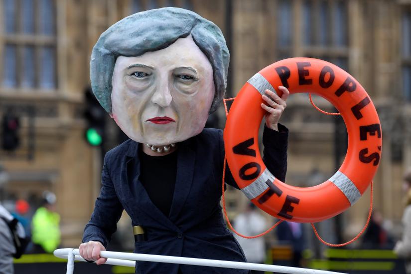 A campaigner dressed as Theresa May holds a prop as part of a campaign stunt promoting a second Brexit referendum, outside the Houses of Parliament in London, Britain, January 15, 2019. REUTERS