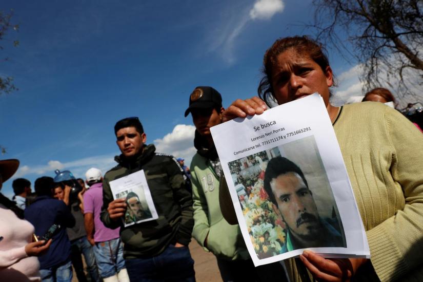 Residents hold pictures of their missing relative at the site where a fuel pipeline ruptured by suspected oil thieves exploded, in the municipality of Tlahuelilpan, state of Hidalgo, Mexico January 19, 2019. REUTERS