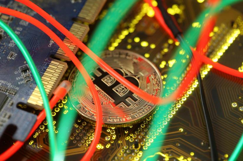Representation of the Bitcoin virtual currency standing on the PC motherboard is seen in this illustration picture, February 3, 2018. REUTERS/Illustration/File Photo