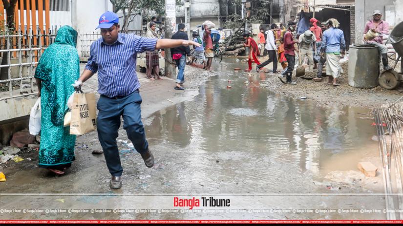 At Dhaka’s Kalabagan Bashir Uddin Road, a multi-storied has been causing public suffering as construction materials left on road have clogged WASA’s drain, resulting in stagnant putrid water. Photo taken on Friday (Jan 20). BanglaTribune/Sazzad Hossain
