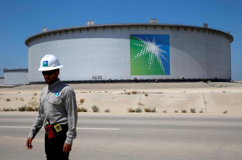 An Aramco employee walks near an oil tank at Saudi Aramco`s Ras Tanura oil refinery and oil terminal in Saudi Arabia May 21, 2018. Picture taken May 21, 2018. REUTERS