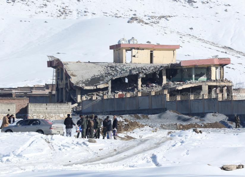 Afghan men stand in front of a collapsed building of a military base after a car bomb attack in Maidan Wardak, Afghanistan, January 21, 2019.  REUTERS