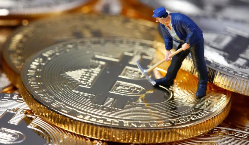 A small toy figure is seen on representations of the Bitcoin virtual currency in this illustration picture. REUTERS/File Photo