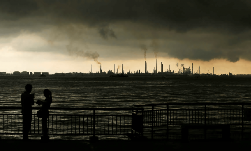 Storm clouds gather over Shell’s Pulau Bukom oil refinery in Singapore. Photograph: REUTERS/File Photo