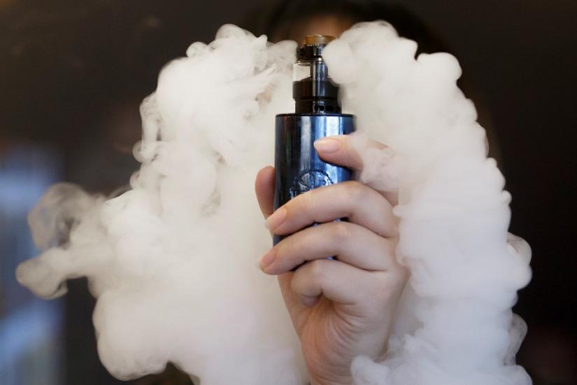 A saleswoman holds an e-cigarette as she demonstrates vaping at the Vape Shop that sells e-cigarette products in Beijing, China January 30, 2019. REUTERS