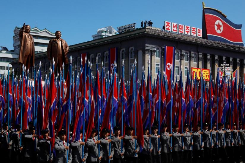 People carry flags in front of statues of North Korea founder Kim Il Sung (L) and late leader Kim Jong Il during a military parade marking the 70th anniversary of North Korea`s foundation in Pyongyang, North Korea, Sept 9, 2018. REUTERS/File Photo