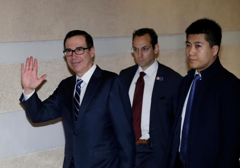 US Treasury Secretary Steven Mnuchin (L), a member of the US trade delegation to China, waves to the media as he leaves a hotel in Beijing, China February 13, 2019. REUTERS
