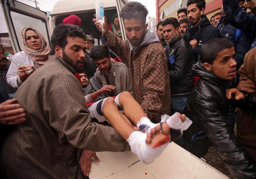 People rush a boy to a hospital in Srinagar for treatment after he was injured in an explosion inside a school in south Kashmir`s Pulwama district February 13, 2019. REUTERS