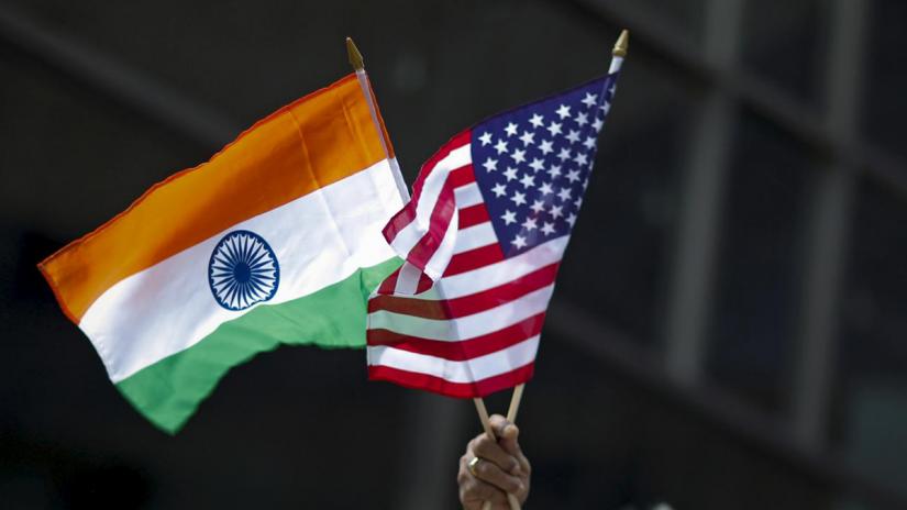 A man holds the flags of India and the U.S. while people take part in the 35th India Day Parade in New York August 16, 2015. REUTERS/File Photo