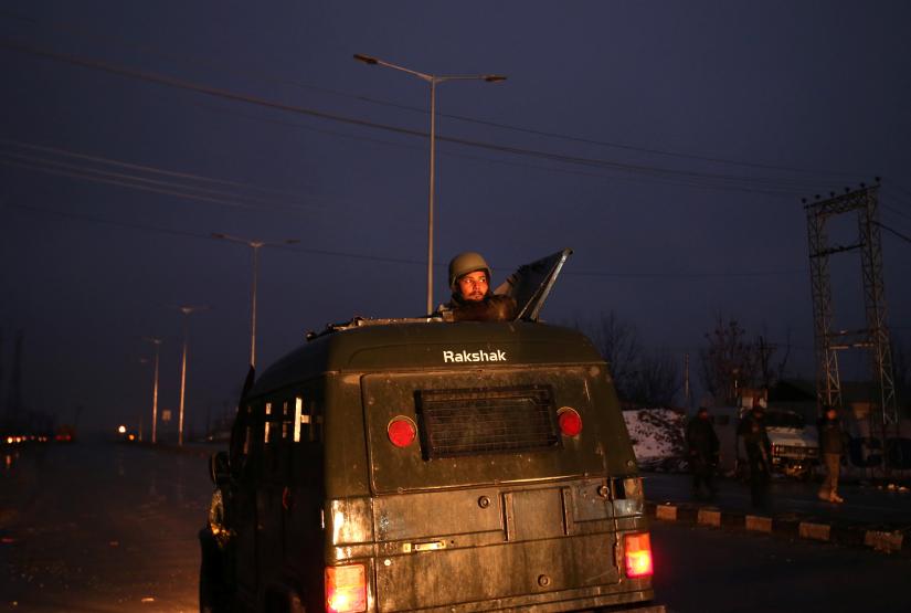 An Indian soldier keeps guards from atop an armoured vehicle near the site of explosion in Lethpora in south Kashmir`s Pulwama district February 14, 2019. REUTERS