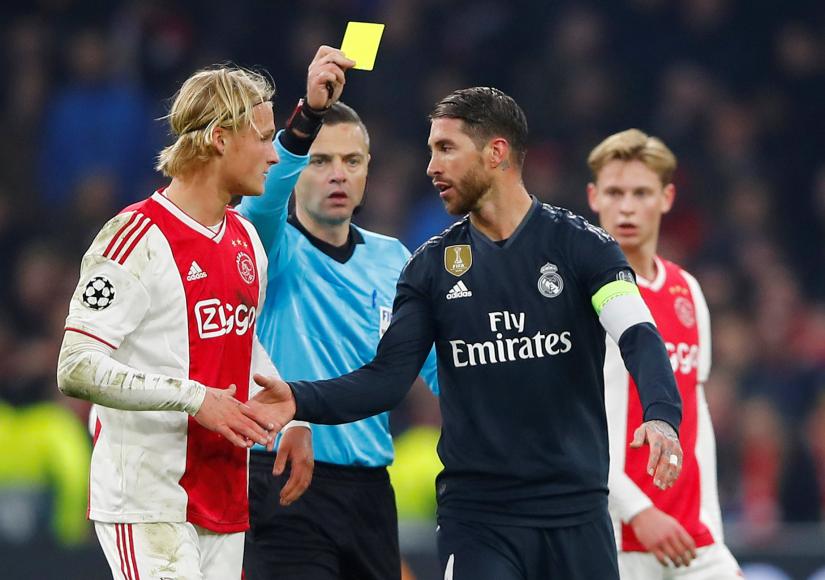 February 13, 2019 Real Madrid`s Sergio Ramos is shown a yellow card by referee Damir Skomina as Ajax`s Kasper Dolberg looks on REUTERS