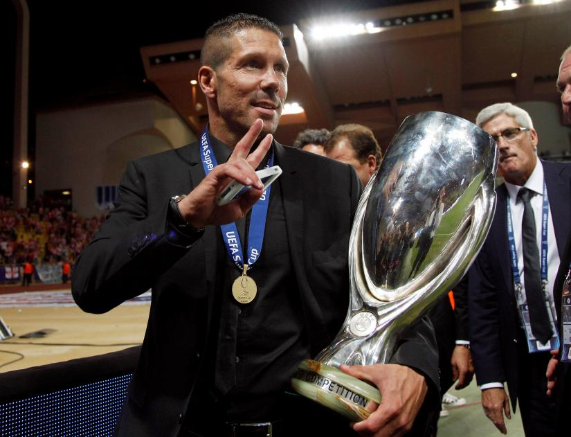 Atletico Madrid`s coach Diego Simeone holds the Super Cup trophy at Louis II stadium in Monaco, August 31, 2012. REUTERS/file photo