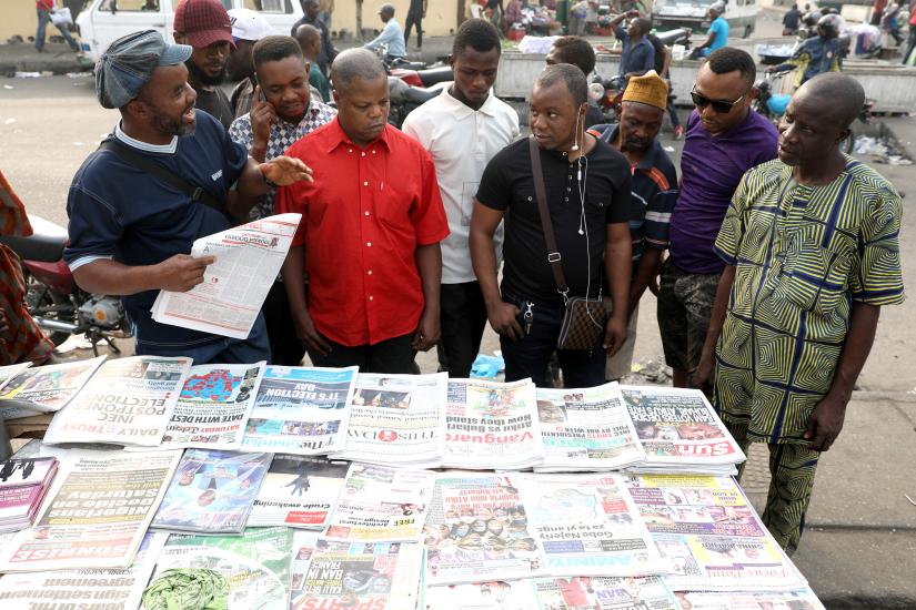 People read newspapers after the postponement of the presidential election in Lagos, Nigeria February 16, 2019. REUTERS