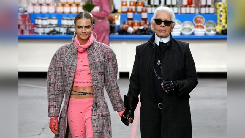 German designer Karl Lagerfeld (R) and model Cara Delevingne appear at the end of his Fall/Winter 2014-2015 women`s ready-to-wear collection show for French fashion house Chanel at the Grand Palais transformed into a `Chanel Shopping Center` during Paris Fashion Week March 4, 2014. REUTERS/File Photo